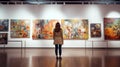 rear view of a women looking at paintings in an art gallery