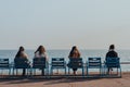 Rear view of women relaxing on blue chairs on The Promenade des Anglais in Nice, France