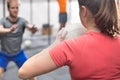 Rear view of woman throwing medicine ball towards man in crossfit gym Royalty Free Stock Photo