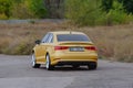 Rear view Yellow sedan drives at high speed on a paved road. Aud Royalty Free Stock Photo