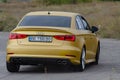 Rear view Yellow sedan drives at high speed on a paved road. Audi RS3 Sportback Quattro car Royalty Free Stock Photo