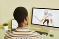 Rear view of young African American designer drawing graphic picture of warrior