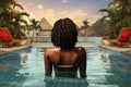 Rear view of a young African American woman in a swimming pool, Rear view of young african american woman relaxing in swimming Royalty Free Stock Photo