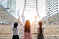 Rear view young asian businesswoman group in formal wear, they raising hands showing success symbol meaning of project successful