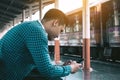 Rear view of young asian hipster man holding mobile phone using Royalty Free Stock Photo