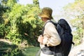 Rear view of a young backpacker male looking while hiking into the mountains in the evening sunset during summer. Royalty Free Stock Photo