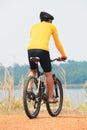 rear view of young bicycle man wearing rider suit and safety helmet riding mountain bike on dirt ground use for man and male act Royalty Free Stock Photo