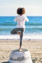 Rear view of young black woman doing yoga in the beach Royalty Free Stock Photo