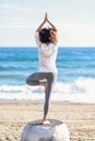 Rear view of young black woman doing yoga in the beach Royalty Free Stock Photo