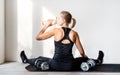 Rear view of young blond woman working out with dumbbells showing her back and arms muscles Royalty Free Stock Photo