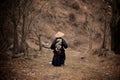 Rear view of a Young boy dressed as Samurai with the painted dragon on Kimono walking by the mountain trail in the cloudy weather Royalty Free Stock Photo