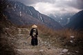 Rear view of a Young boy dressed as Samurai with the painted dragon on Kimono walking by the mountain trail in the cloudy weather Royalty Free Stock Photo