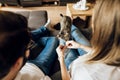 Rear view of young couple with adorable cat sitting on sofa Royalty Free Stock Photo