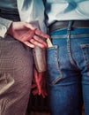 Rear View Of young couple holding hands, the second hand wife pulls money from the pocket of her husband`s denim trousers until h