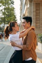 Rear view of a young couple hugging in a destination city while standing in the shopping district near a luxury quality shoe store Royalty Free Stock Photo