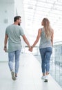 Rear view.a young couple passes through the corridor of a modern building. Royalty Free Stock Photo