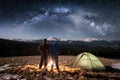Rear view young couple tourists having a rest in the camping at nigh under night sky full of stars and milky way Royalty Free Stock Photo