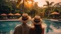 Rear view, Young couple traveler relaxing and enjoying view near pool at resort while traveling for summer vacation Royalty Free Stock Photo