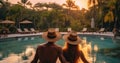Rear view, Young couple traveler relaxing and enjoying view near pool at resort while traveling for summer vacation Royalty Free Stock Photo
