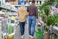 Rear view on young couple walking past the shelves with flowers Royalty Free Stock Photo
