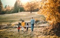 A rear view of young family with two small children walking in autumn nature. Royalty Free Stock Photo