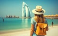 Rear view Young girl with backpack in a hat standing looks into the Burj Al Arab, United Arab Emirates