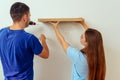 Man using a drill to install bookshelf on the wall Royalty Free Stock Photo