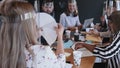 Rear view young happy female leader cooperating with multiethnic business team at office meeting, all wear face shields. Royalty Free Stock Photo