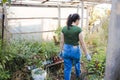 Rear view of a young latin farmer woman entering her organic garden.