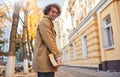 Rear view of young man with glasses posing with book outdoors. College male student carrying books in campus in autumn street. Royalty Free Stock Photo