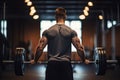 Rear view of a young man lifting a barbell in a gym, Weightlifter man practicing with barbells at the gym, top section cropped, no