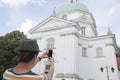 Rear view of young man photographing St. Casimir Church, Warsaw, Poland