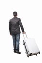 Rear view of young man and pulling belonging luggage walking to