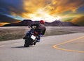 Rear view of young man riding motorcycle in asphalt road curve w