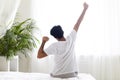 Rear View Of Young Man Stretching In Bed After Waking Up In The Morning Royalty Free Stock Photo