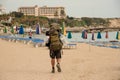 Rear view young man walking with a hiking backpack on the sea coast