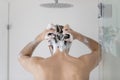 Rear view young man washing hair, standing in bathroom Royalty Free Stock Photo