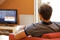 Rear view of young man watching television Royalty Free Stock Photo