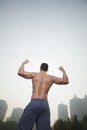 Rear view of young, muscular man with no shirt on flexing his back muscles, outdoors in Beijing, China Royalty Free Stock Photo