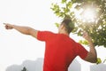 Rear view of young muscular man stretching by a tree, arms raised and fingers pointing towards the sky in Beijing, China with lens Royalty Free Stock Photo