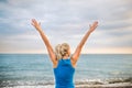 Rear view of young sporty woman runner in blue sportswear standing on the beach. Royalty Free Stock Photo