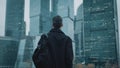 Rear view of a young unrecognizable businessman walking and looking at skyscrapers in a summer evening. Moscow city Royalty Free Stock Photo