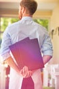 Rear view of young waiter holding menus while standing at restaurant