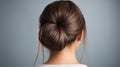 Rear view of young woman elegant bun hairstyle, grey background, copy space