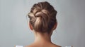 Rear view of young woman elegant bun hairstyle, grey background, copy space