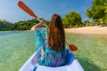 Young woman paddling a canoe along the shore of an idyllic islan Royalty Free Stock Photo