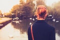 Rear view of young woman looking at birds by a river Royalty Free Stock Photo