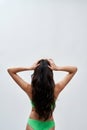 Rear view of young woman with perfect slim body wearing green underwear posing against light background, showing off her Royalty Free Stock Photo