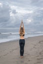 rear view of young woman practicing yoga in Mountain pose (Tadasana) on seashore Royalty Free Stock Photo