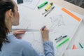 Rear view of a young woman prepares architectural work at the table with a white drawing Board, ruler and pencil